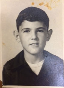 A stained black and white school picture of Glen as a young boy, possibly 10 or 11.